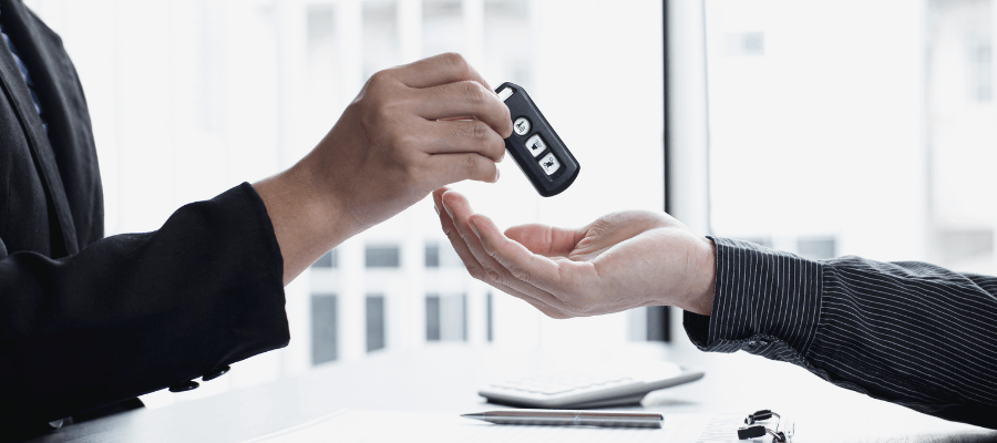 Auto lender handing vehicle keys to a borrower after financing